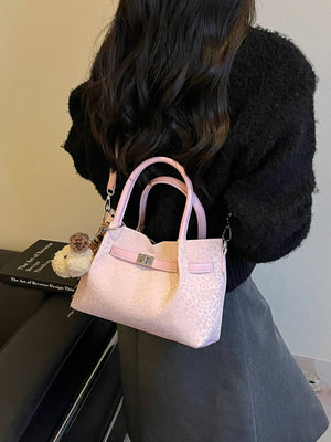 Pink crossbody bag featuring buckle detail and leopard