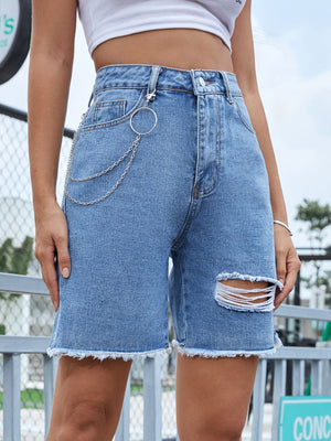 Distressed denim bermuda shorts in light wash with frayed hem and chain detail.