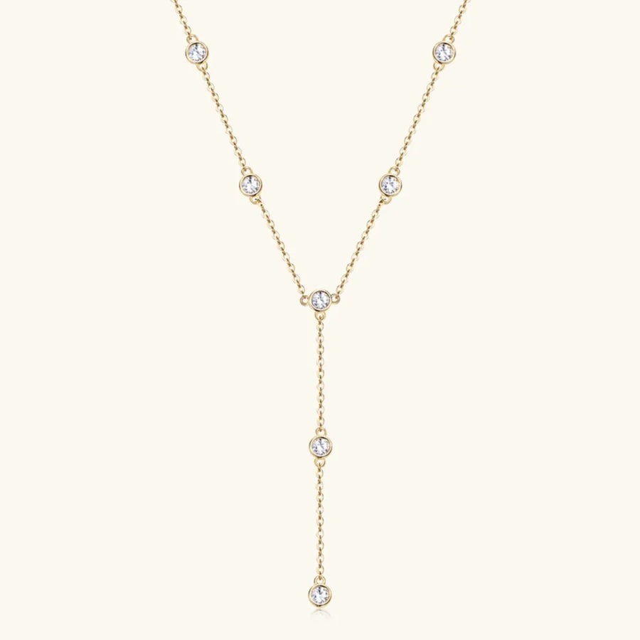 Gold lariat necklace with bezel-set moissanite drops.