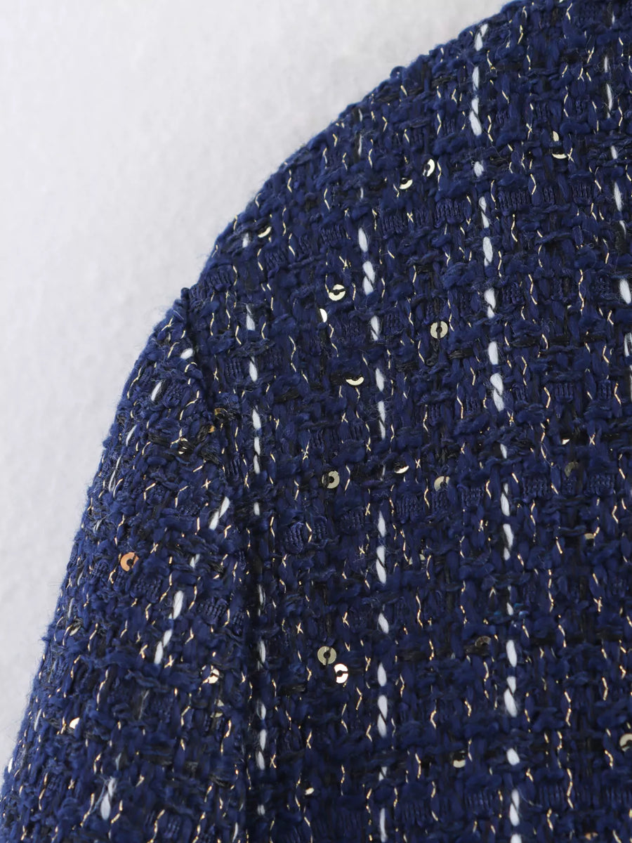 Dark blue cropped tweed jacket with gold and white flecks and sequins.