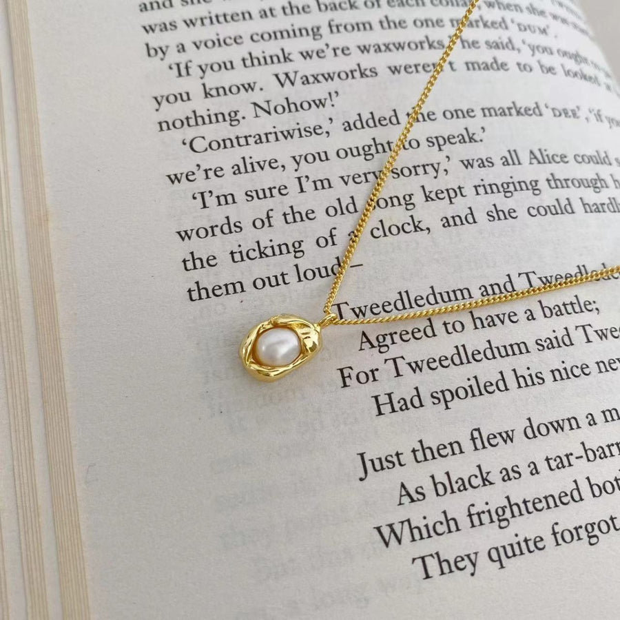 Gold pearl pendant necklace with organic setting on a delicate chain.