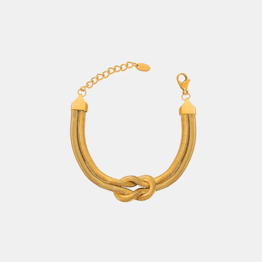 Gold serpent knot cuff bracelet with adjustable chain and clasp.