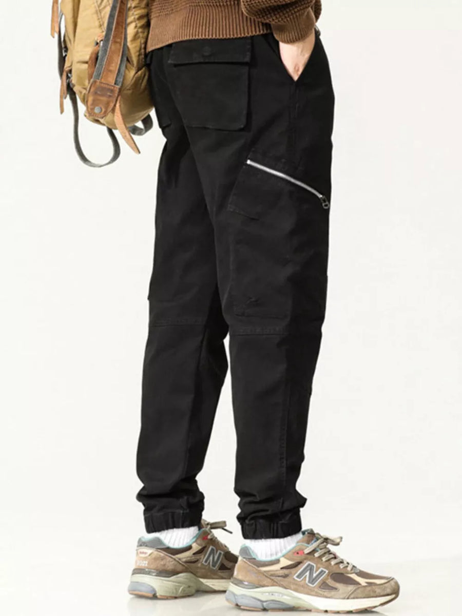 Black cotton cargo pants with zipper pockets and flap pockets.