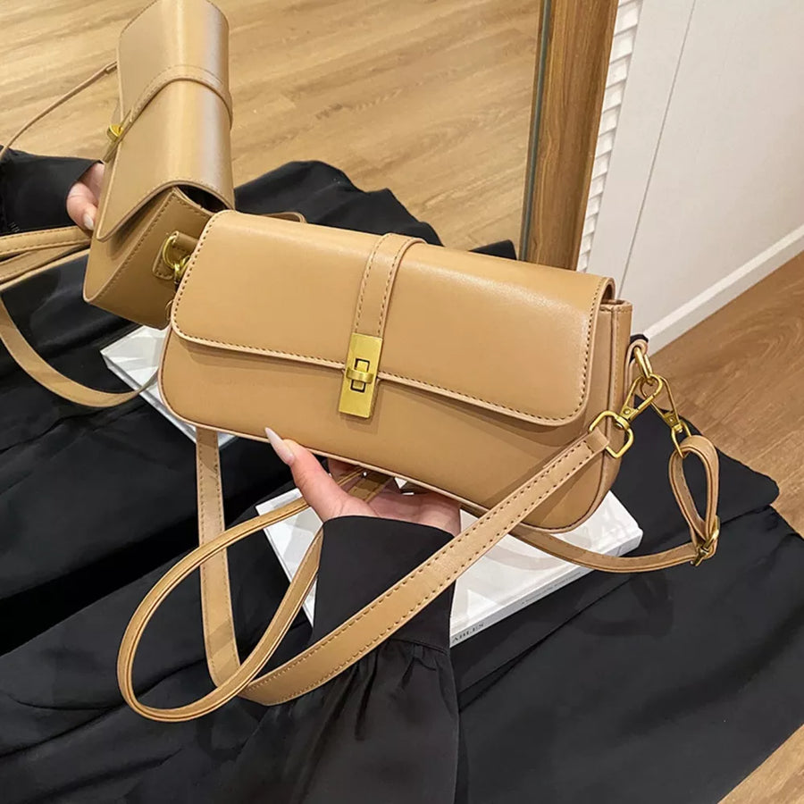 Sleek rectangular crossbody bag in taupe with gold clasp and adjustable strap.