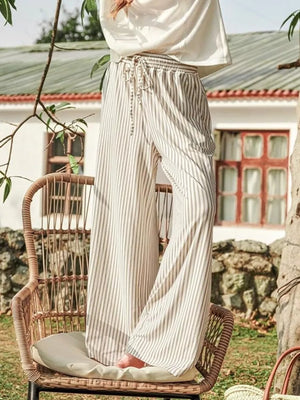 wide-leg pants in cream featuring drawstring waist and flared fit
