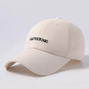 Beige cotton baseball cap with embroidered "GATHERING" text