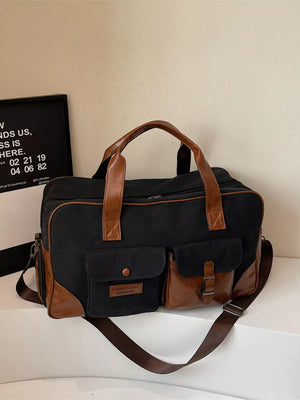 Black canvas travel bag with brown leather accents and multiple pockets.