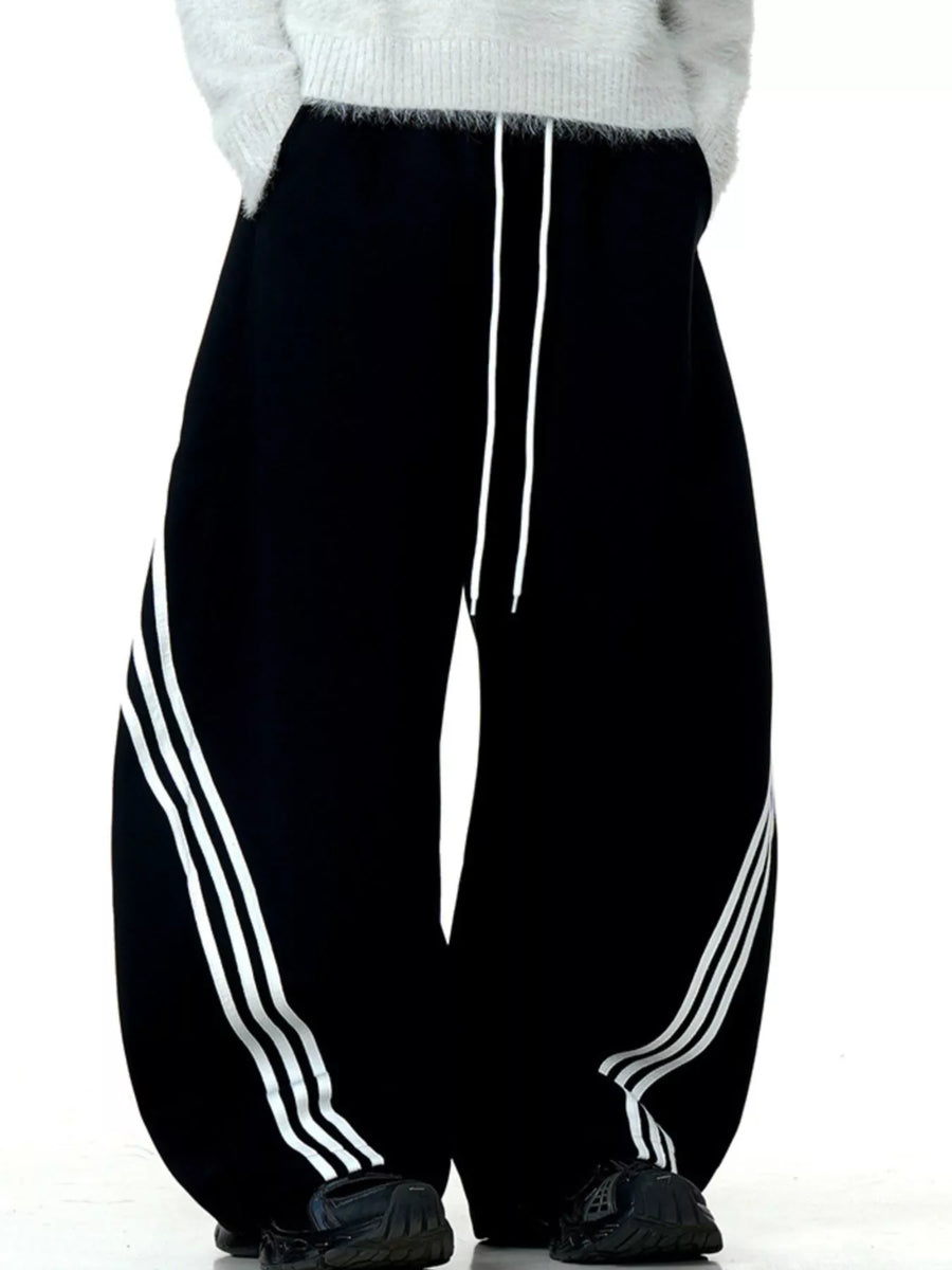 Men's black wide-leg sweatpants with white side stripes and drawstring waist.