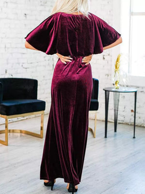 Burgundy velvet maxi dress with flutter sleeves and cinched waist.