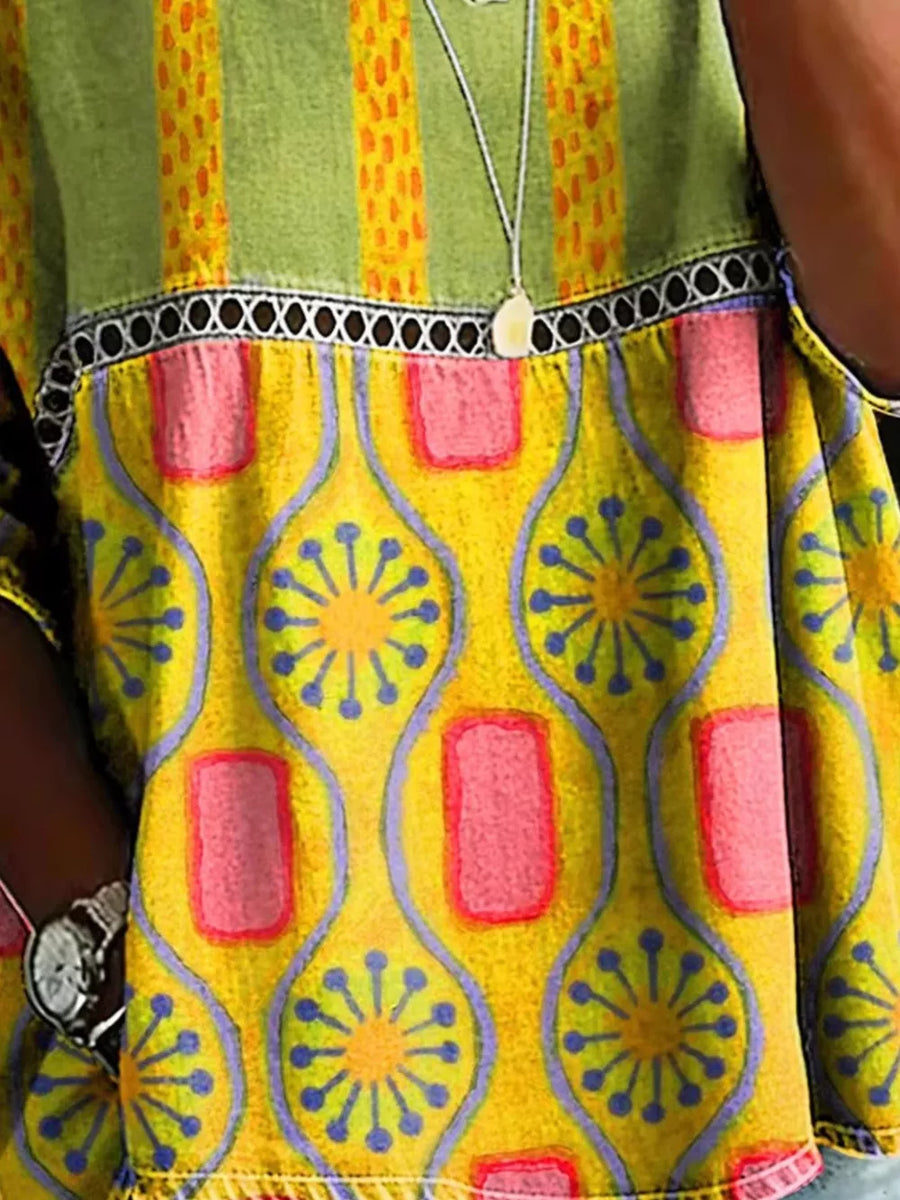 Bohemian maternity t-shirt in yellow with floral and geometric print, openwork detail, and striped green yoke.