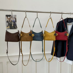Chic mini suede crossbody bags with charm in blue, red, brown, yellow, and tan.