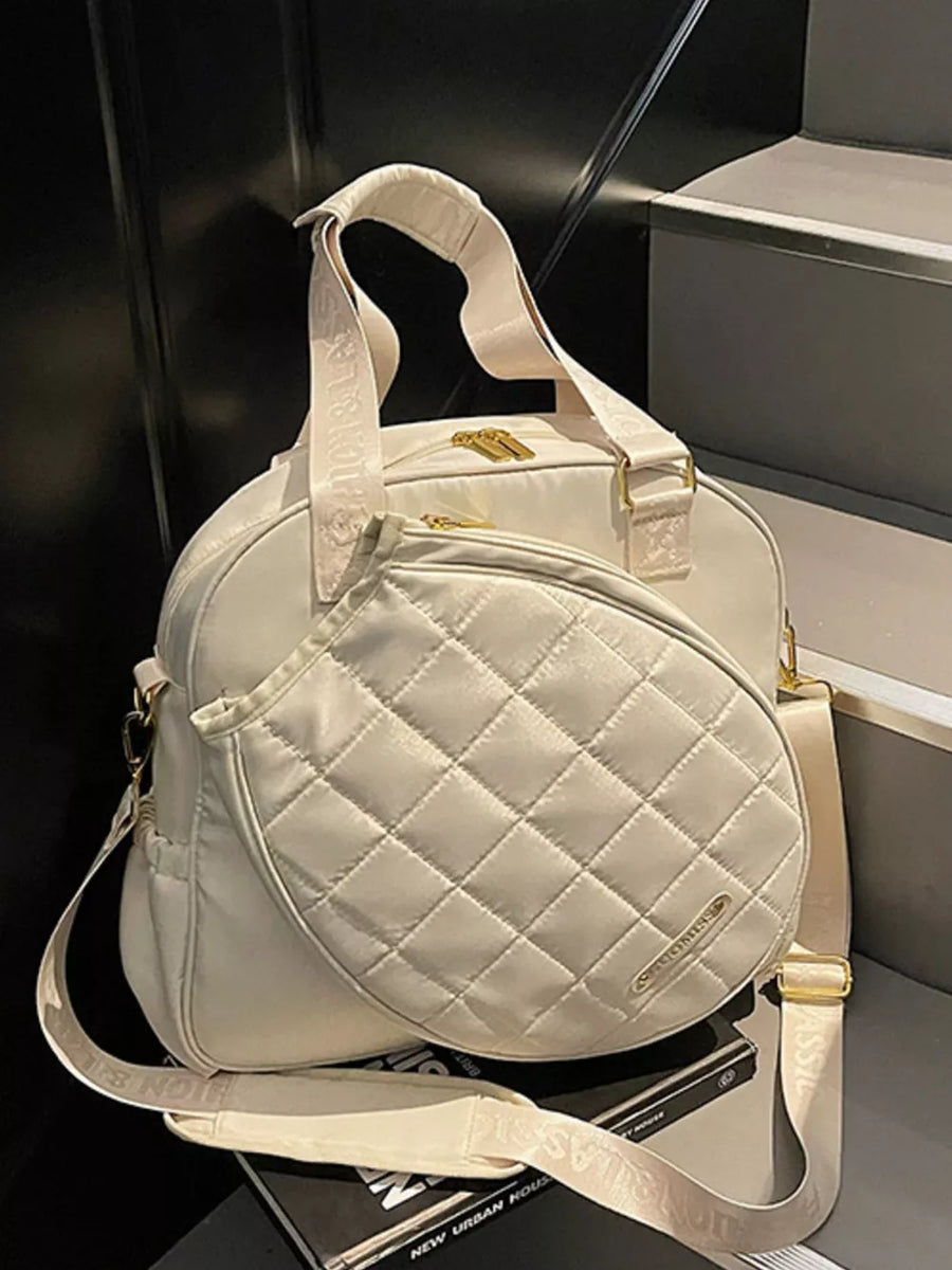 Quilted Oxford bag in off-white with adjustable strap and racket compartment.