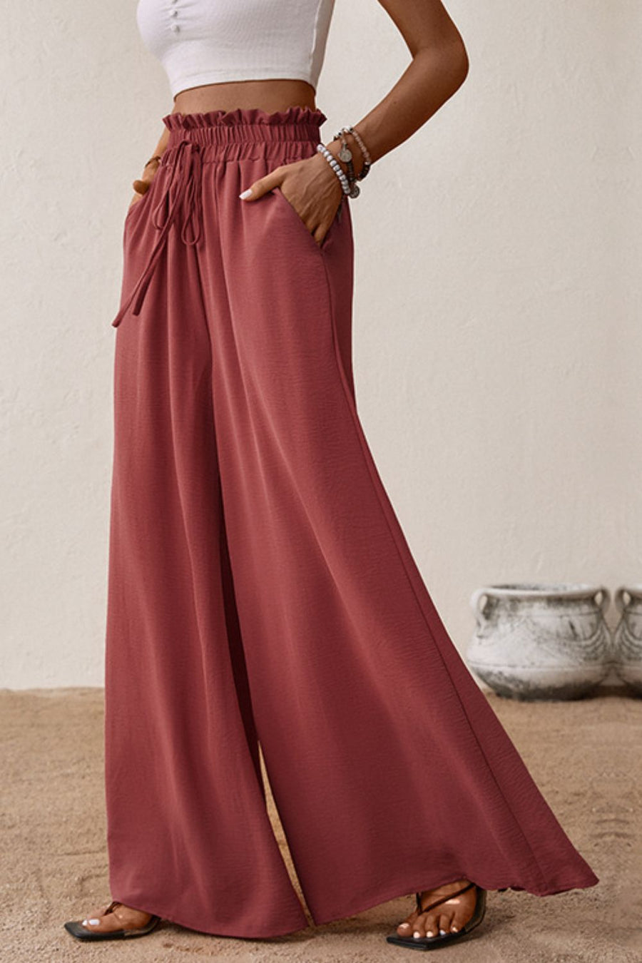 Crimson palazzo trousers with paperbag waist, drawstring, and pockets.