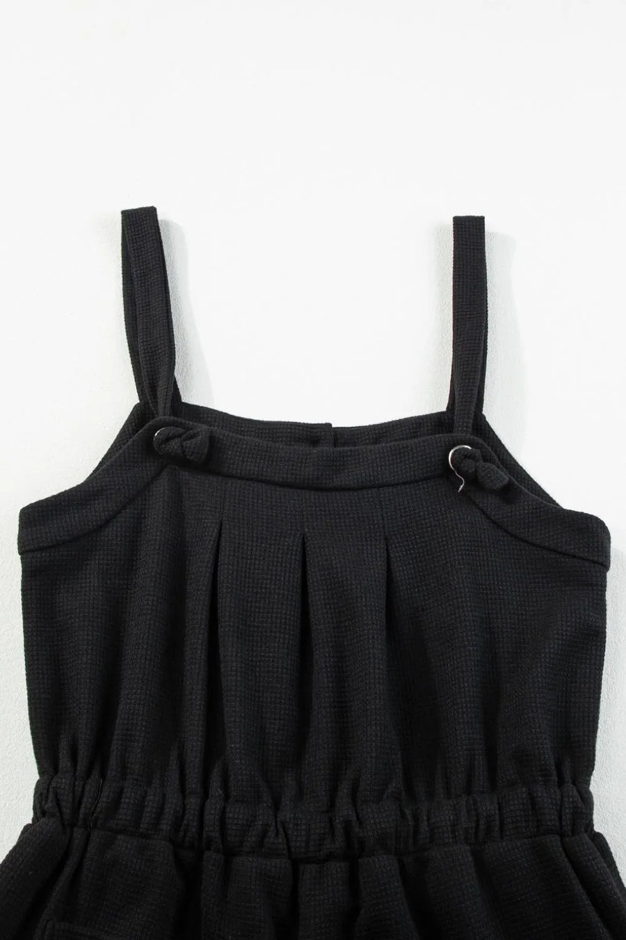 Black waffle knit jumpsuit with adjustable tie straps and elastic waist