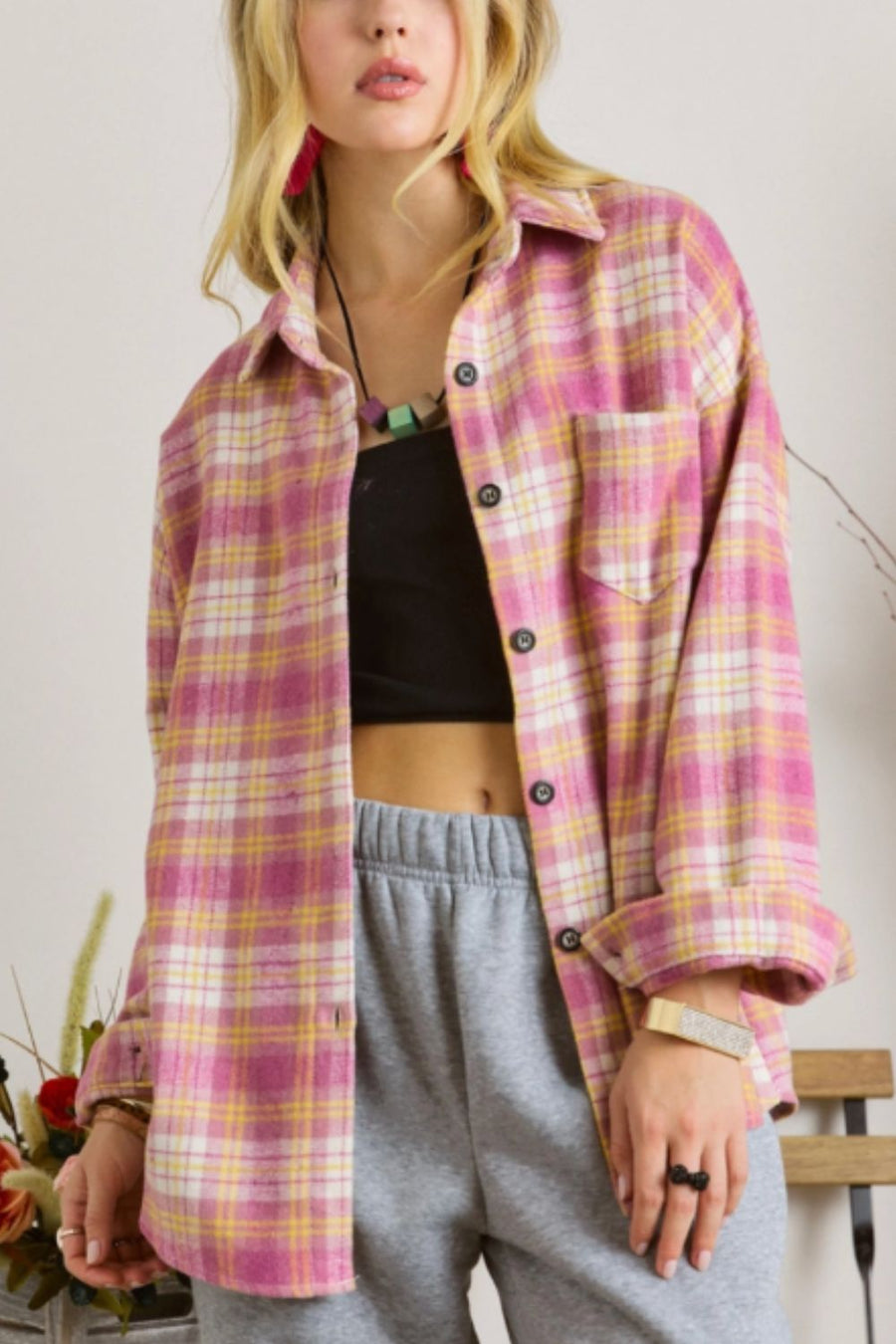 Oversized pink plaid flannel overshirt with button-down front and chest pocket.