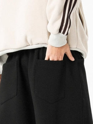 Men's black drawstring wide leg sweatpants with back pockets.