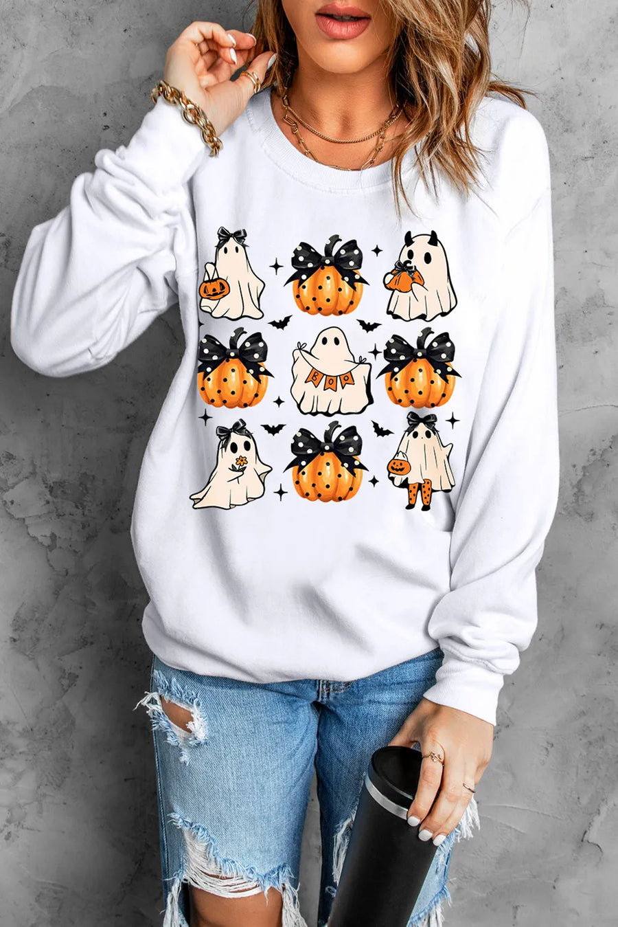 White sweatshirt with a spooky patchwork graphic of ghosts and pumpkins, long sleeves, crew neck.
