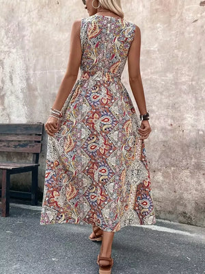 Maternity swim dress in multicolor paisley print, sleeveless with cinched waist and dramatic slit.