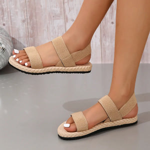 Tan rope-sole cross-strap sandals with elastic straps and a braided sole detail.