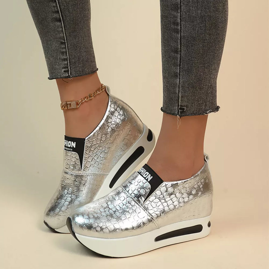 Silver metallic crocodile-embossed platform sneakers with chunky white soles.