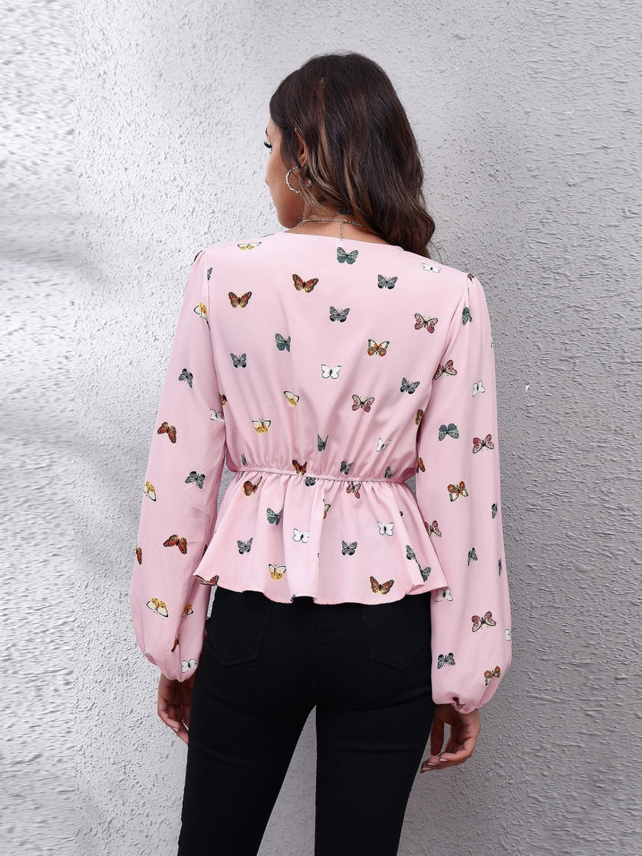 Blush pink peplum blouse with allover butterfly print, cinched waist, and balloon sleeves.