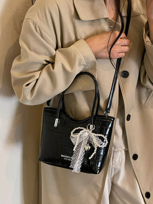 crossbody bag in black featuring top handle and boxy fit