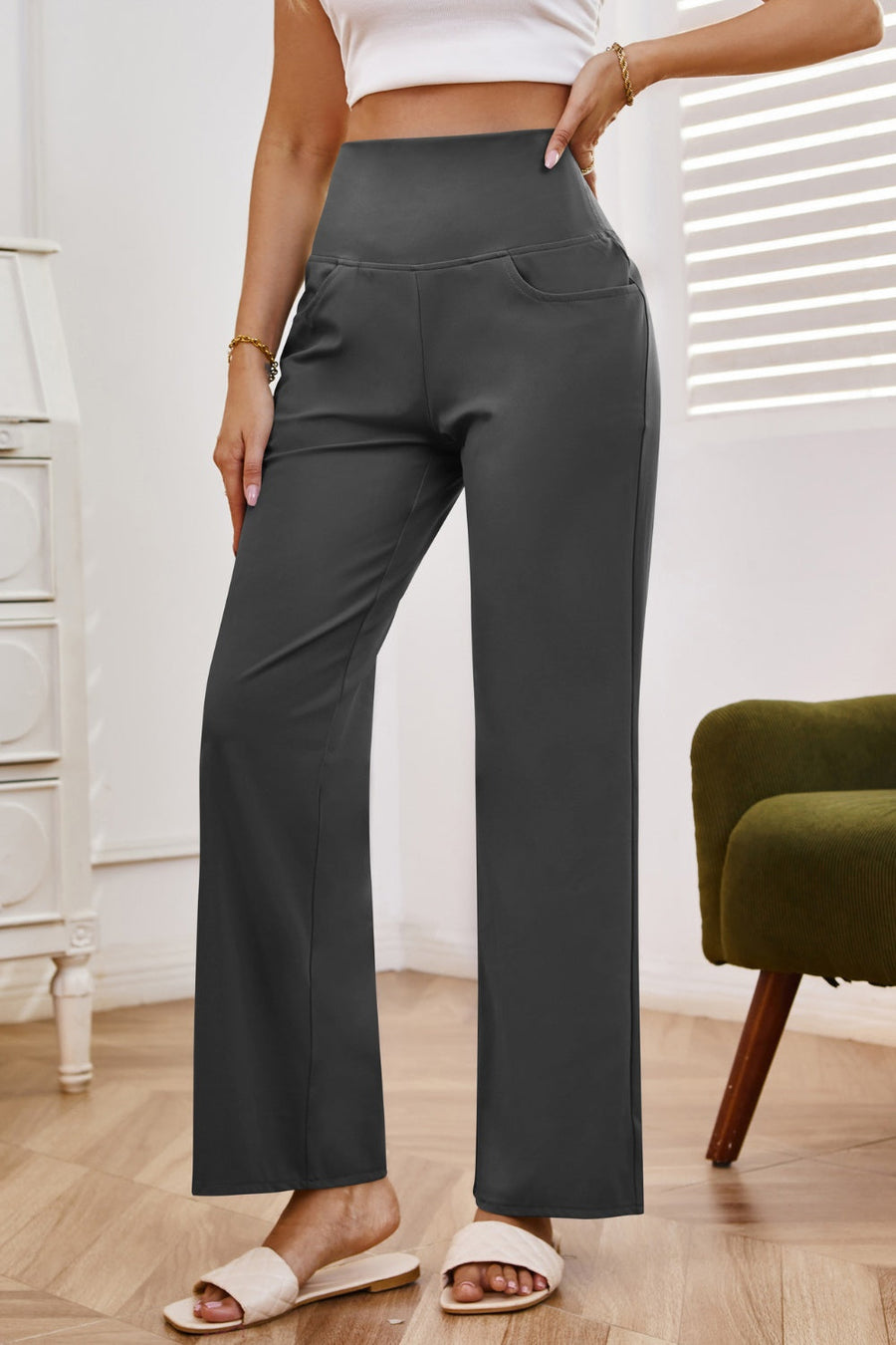 High-waisted flare leg trousers in dark gray with side pockets.
