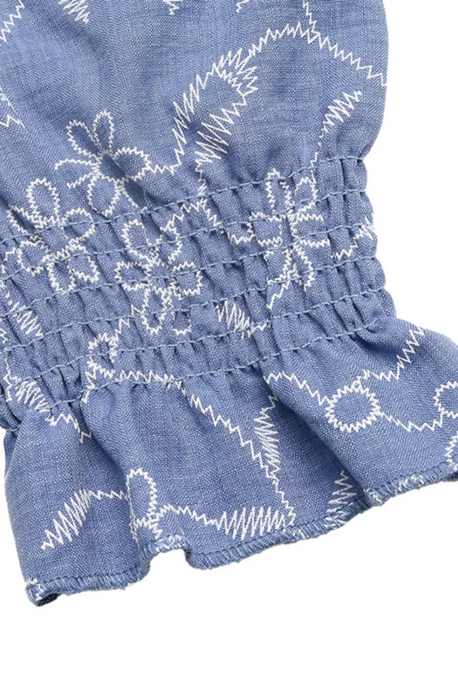 Maxi dress with smocked waist detail and white floral embroidery on blue fabric