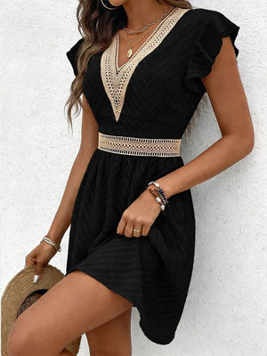 Black chevron textured mini dress with V-neck and defined waist detail