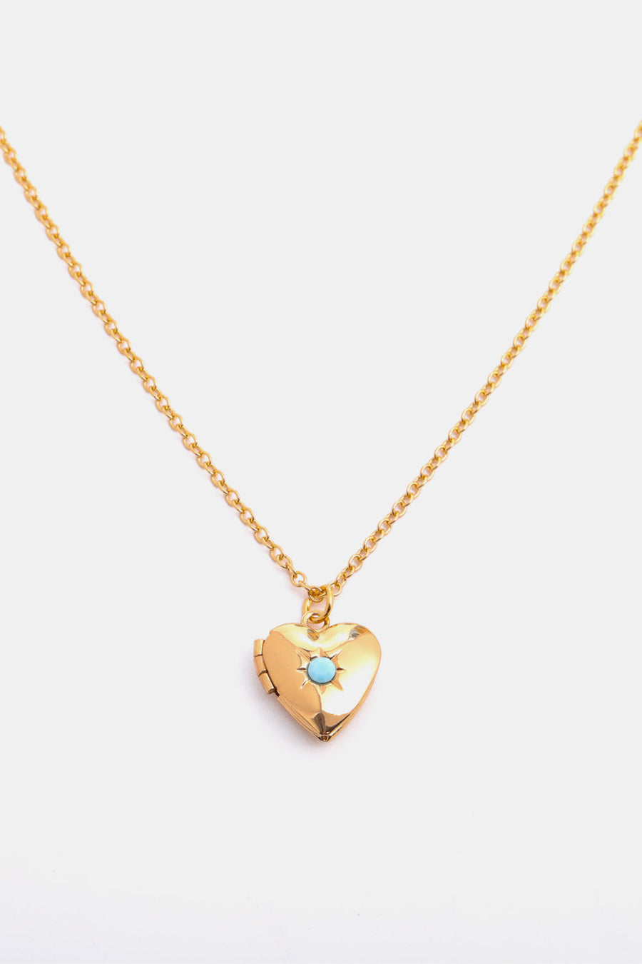 Gold heart locket necklace with turquoise gemstone detail on a delicate chain.