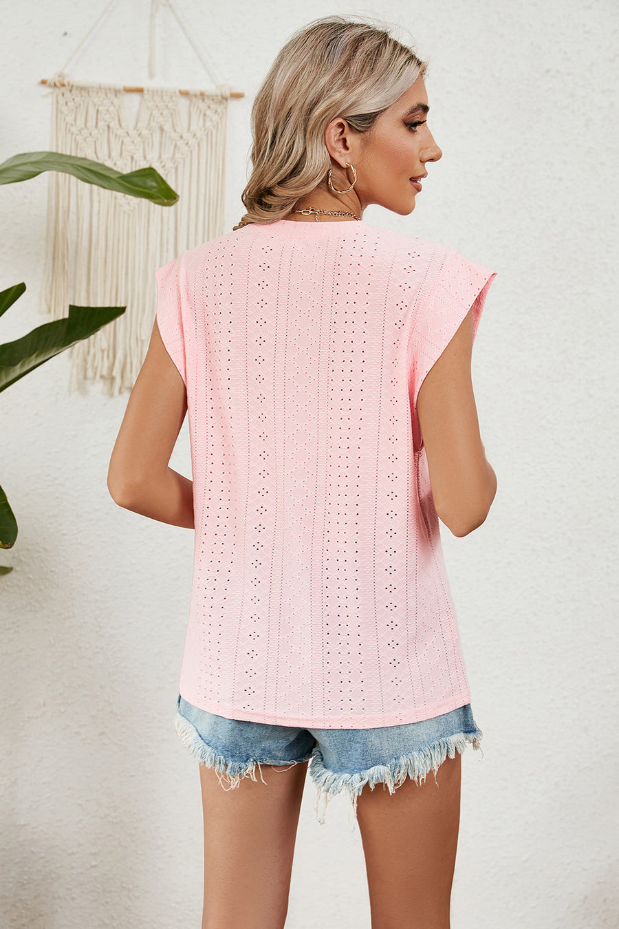 Blush pink perforated shoulder-pad top with cap sleeves and a casual cut.