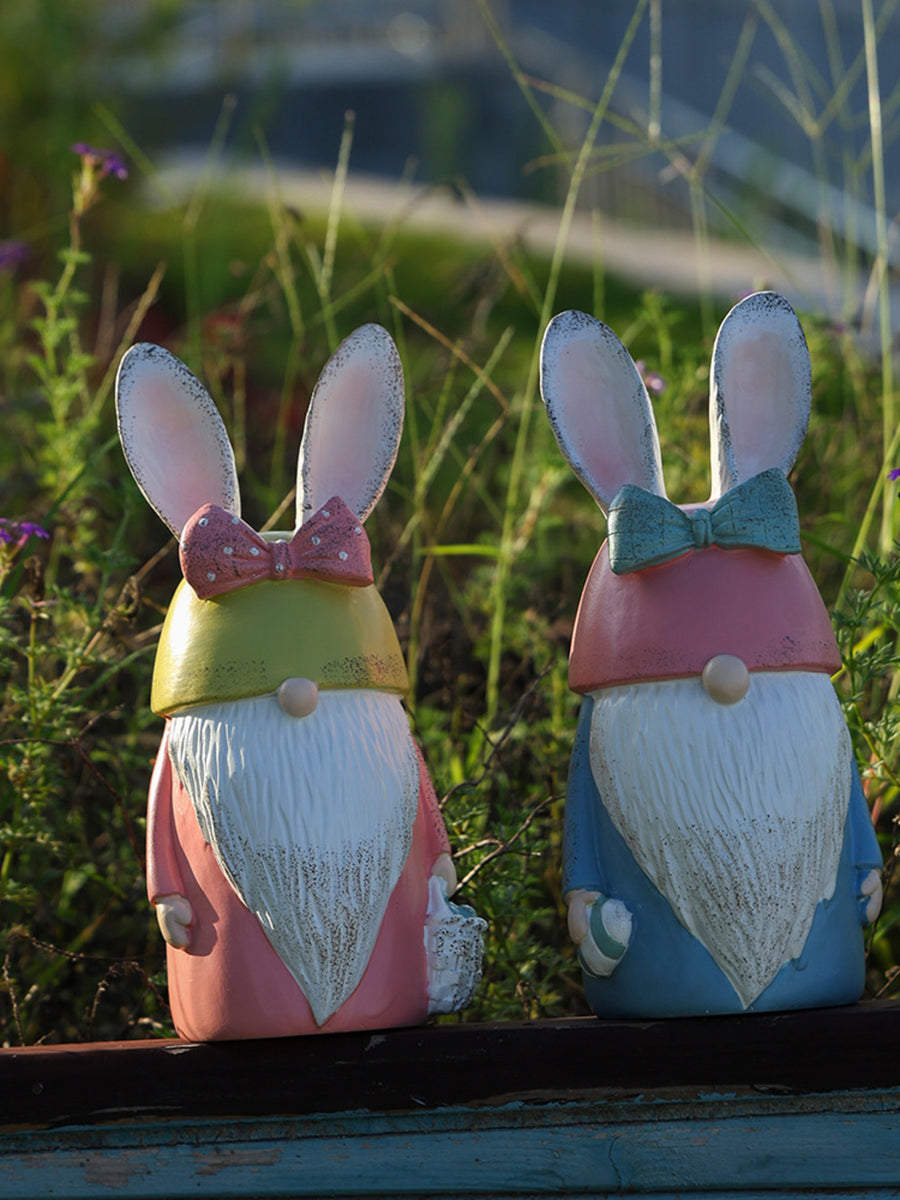 Easter bunny gnome figures in pastel blue and blush pink with bow ties and baskets.