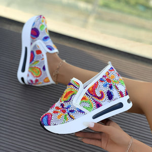 Vibrant slip-on platform sneakers with colorful paisley embroidery and white soles.