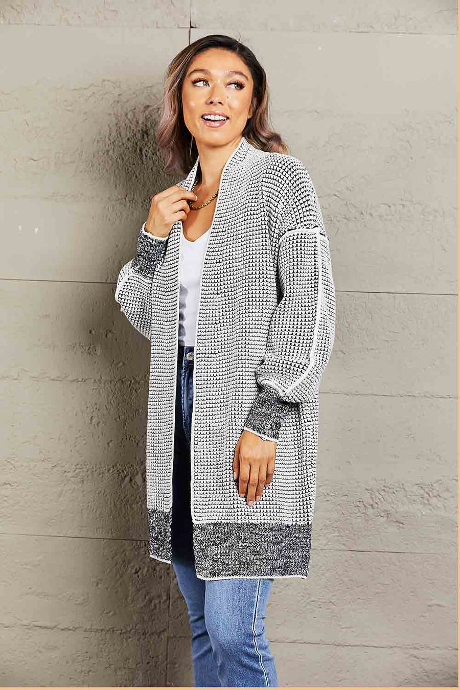 Textured puff sleeve open cardigan in black with a waffle knit pattern and contrast cuffs and hem.
