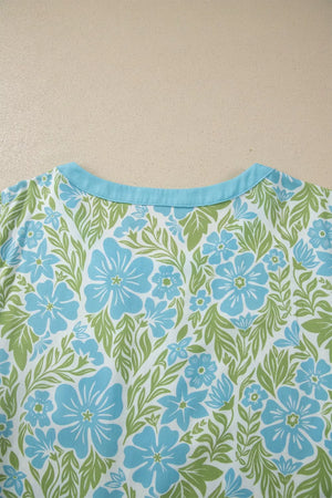 Floral ruffled half sleeve maternity blouse with blue flowers and green leaves pattern.