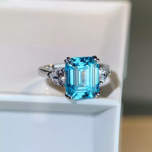 silver ring featuring emerald cut stone and geometric