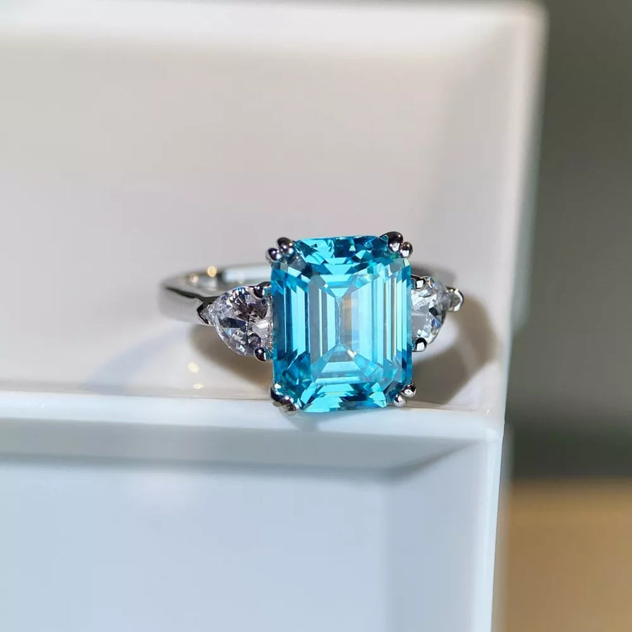silver ring featuring emerald cut stone and geometric