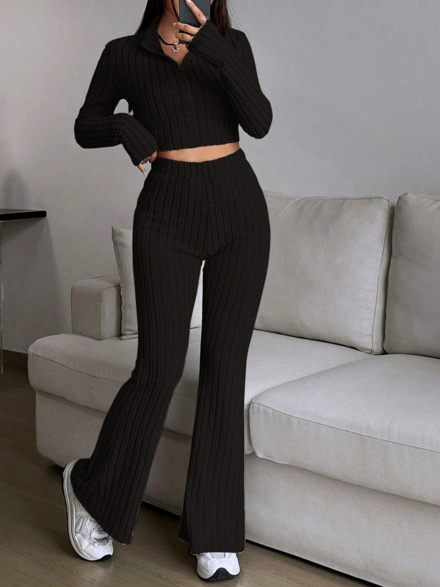 Black ribbed knit flare co-ord set with zip-neck crop top and high-waisted flared pants.