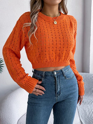 Orange backless openwork knit sweater with basketweave pattern and cropped length.