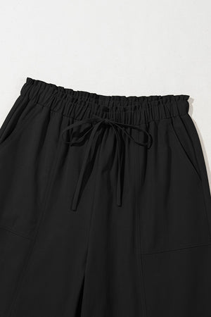 Black cropped drawstring pants with elastic waist and pockets.