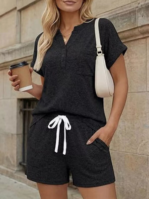 Relaxed two-piece set in black with pocketed top and drawstring shorts.