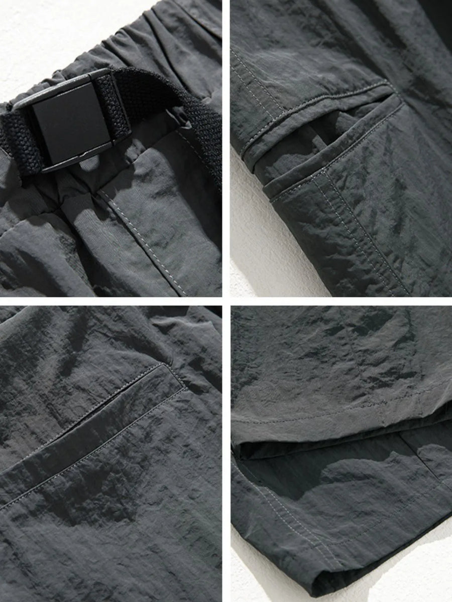 Dark gray technical fabric cargo pants with belt detail, cargo pockets, and stitching.