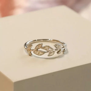 Delicate sterling silver ring with a detailed leaf design and small stones.