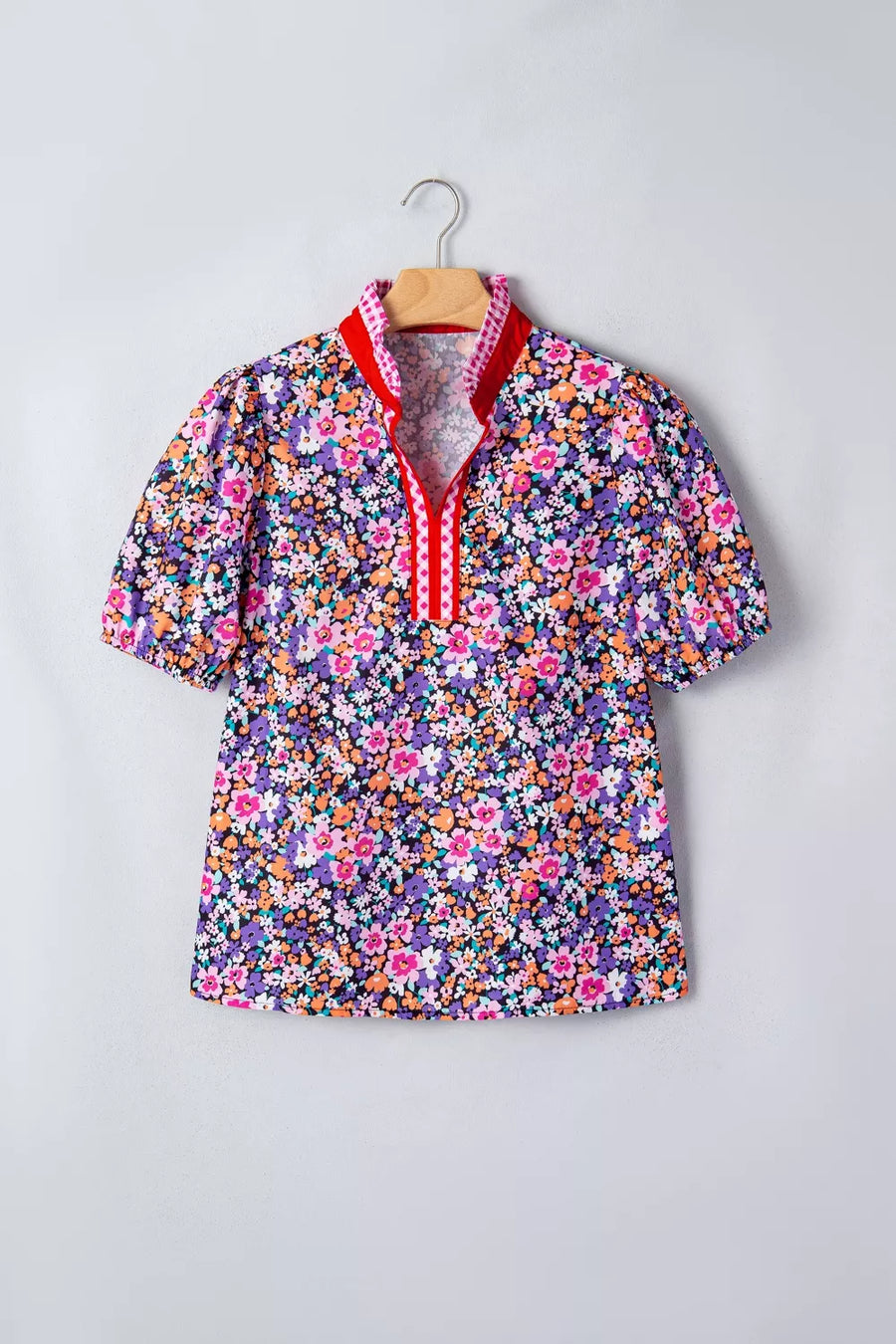 Floral print polyester shirt with v-neck, puff sleeves, and plaid trim detail.