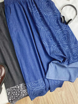 Blue denim jeans with drawstring waist and allover rose print detail.