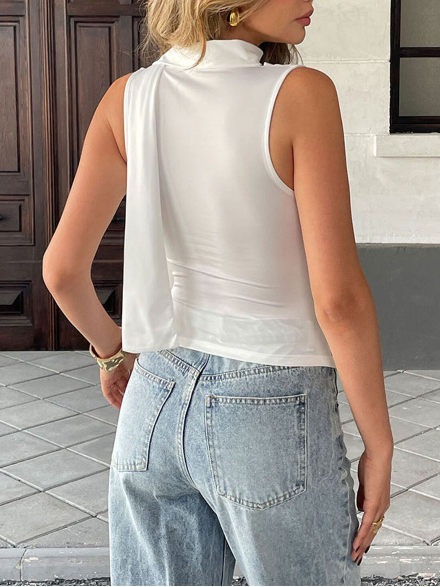 White draped cowl neck cami top with a flowing detail on the side.