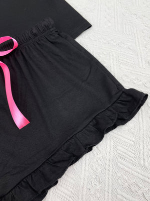 Black ruffled shorts with pink ribbon tie