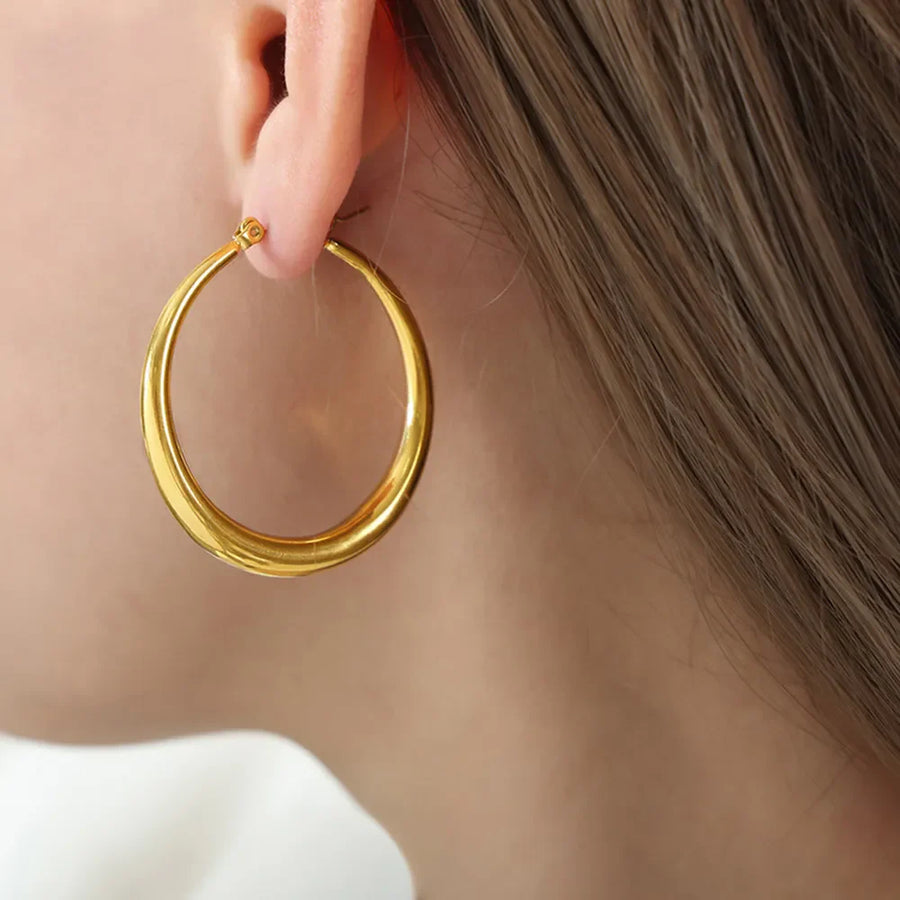 Sculpted oval gold hoop earrings with a polished finish.