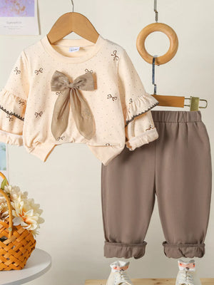 Tan baby outfit with ruffle sleeve top featuring bow print and large bow detail, paired with matching pants.