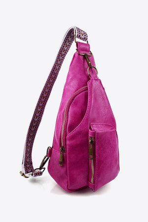 Textured magenta sling bag with woven strap detail and multiple zippered pockets.